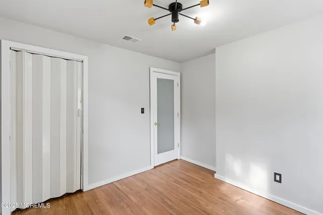 a view of room with hardwood floor and fan