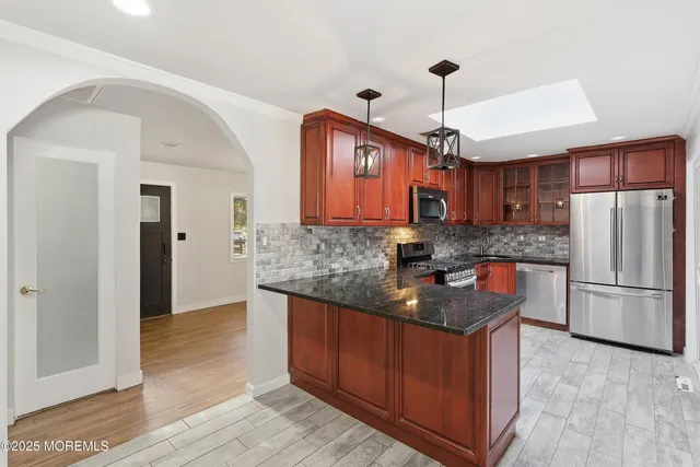 a kitchen with stainless steel appliances granite countertop a sink refrigerator and cabinets