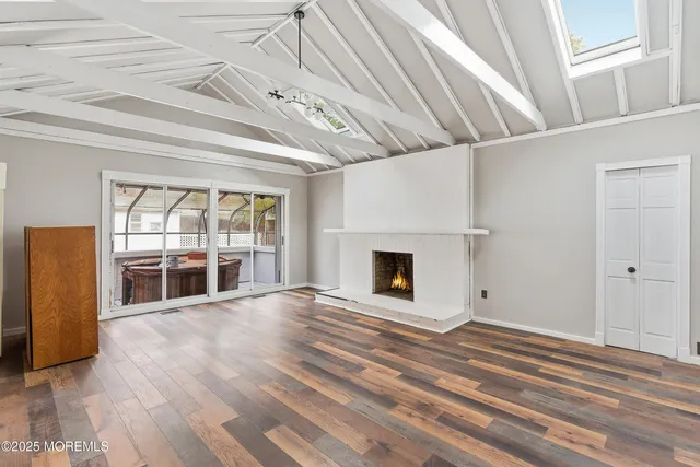 en empty room with wooden floor and fireplace