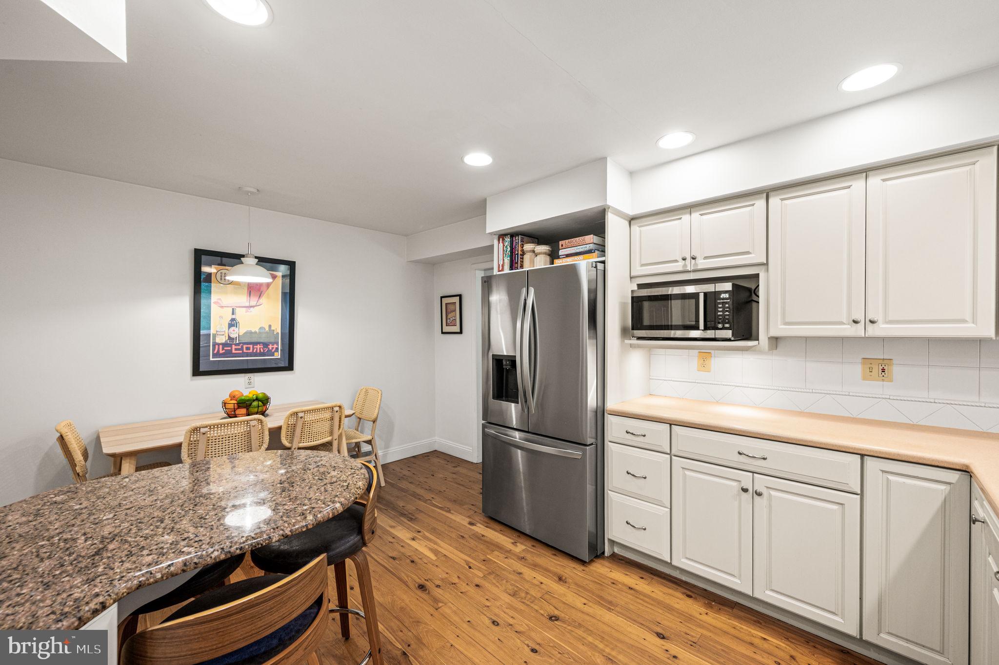 434 Pugh Road Wayne, PA 19087 - Photo 19 of 47 a kitchen with granite countertop kitchen island stainless steel appliances a refrigerator a stove a sink a dining table and chairs