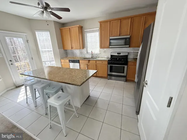 a kitchen with granite countertop a stove cabinets and a refrigerator