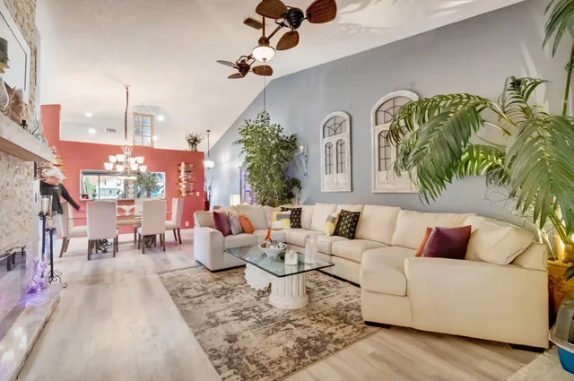 a living room with furniture kitchen view and large windows