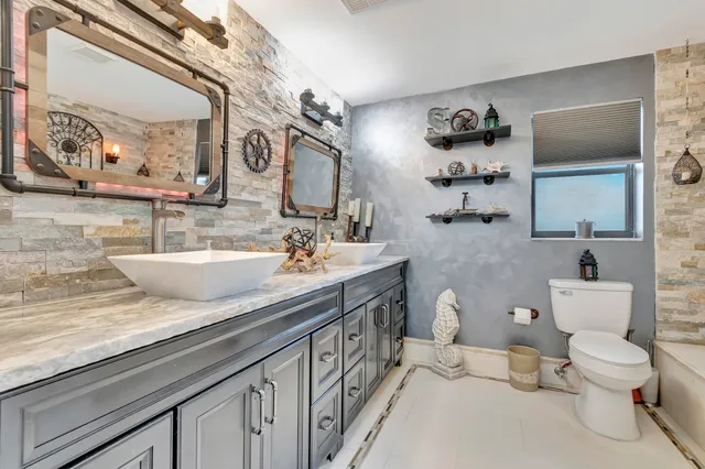 a spacious bathroom with a granite countertop sink and a mirror