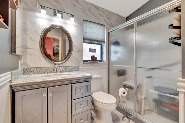 a bathroom with a toilet a sink and a mirror