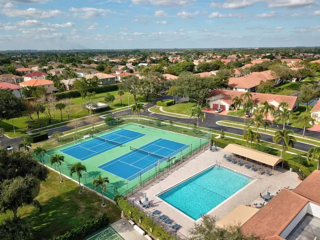 an aerial view of a pool yard and mountain view in back