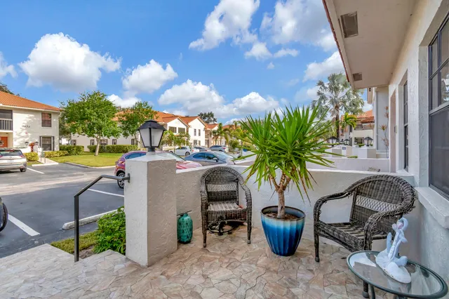 a view of a patio with plants and chairs