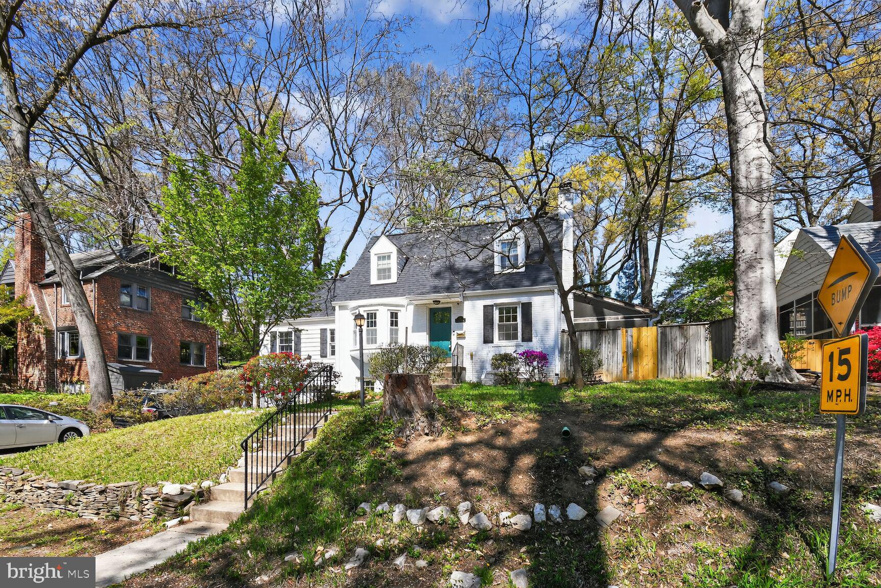 a front view of a house with a yard and large trees