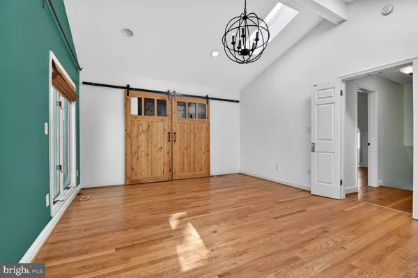 a view of an empty room with wooden floor