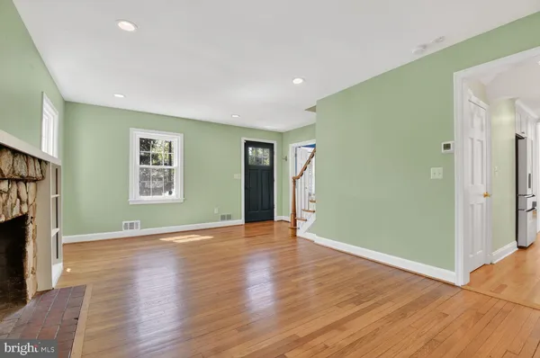 an empty room with wooden floor and a fireplace