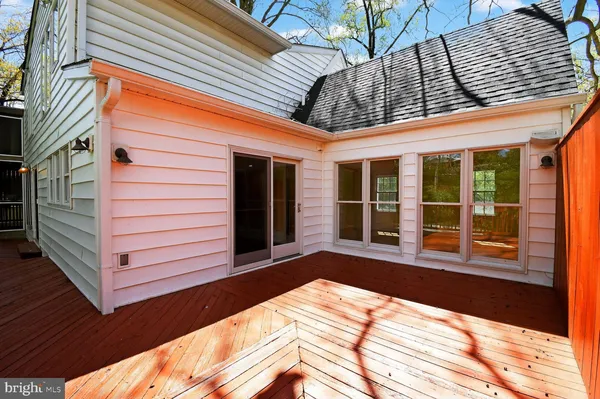 a view of a white house with a large tree in front of it