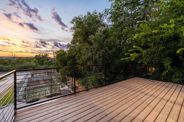 a view of balcony with wooden floor and fence