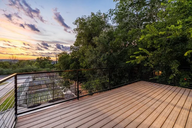 a view of balcony with wooden floor and fence