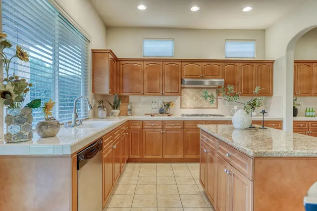 a kitchen with granite countertop a sink and cabinets