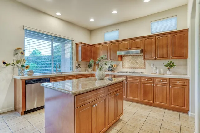 a kitchen with stainless steel appliances granite countertop a refrigerator and a stove top oven