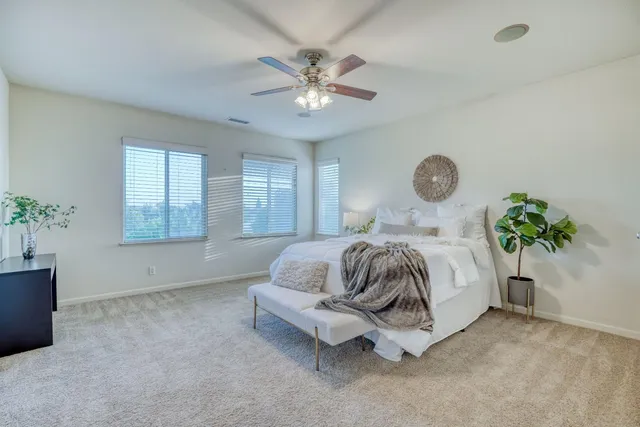 an empty room with a window and a ceiling fan