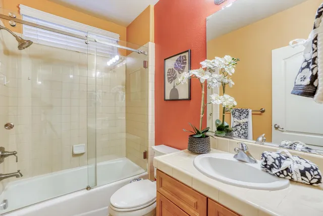 a front view of a house with a garden and trees