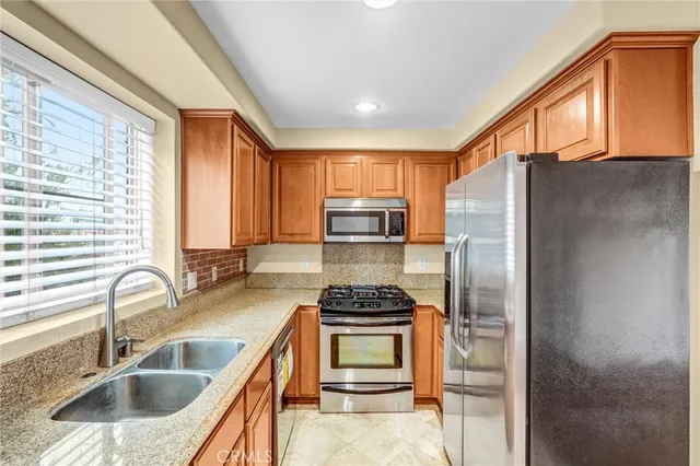 a kitchen with granite countertop a sink stainless steel appliances and cabinets
