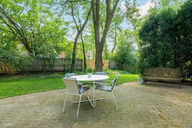 a view of a house with a big yard and large trees