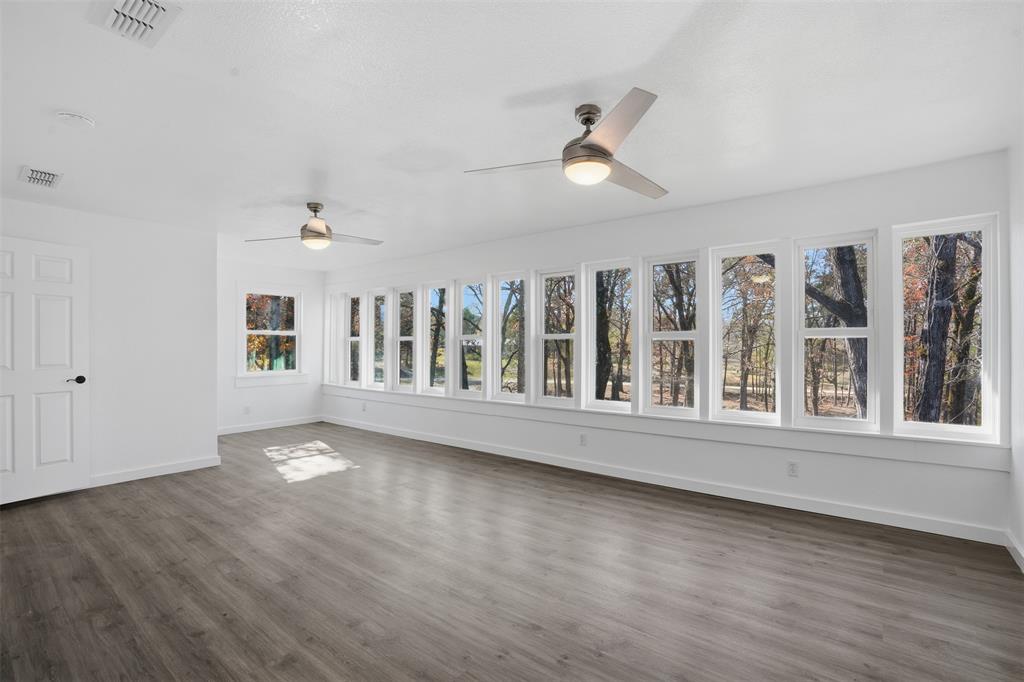 3148 Medlin Road East Mountain, TX 75645 - Photo 11 of 36 an empty room with wooden floor and windows