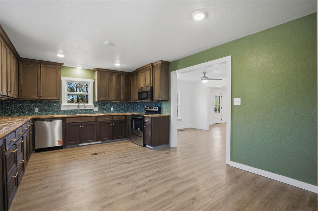 3148 Medlin Road East Mountain, TX 75645 - Photo 12 of 36 a large kitchen with stainless steel appliances granite countertop a stove a sink and a refrigerator