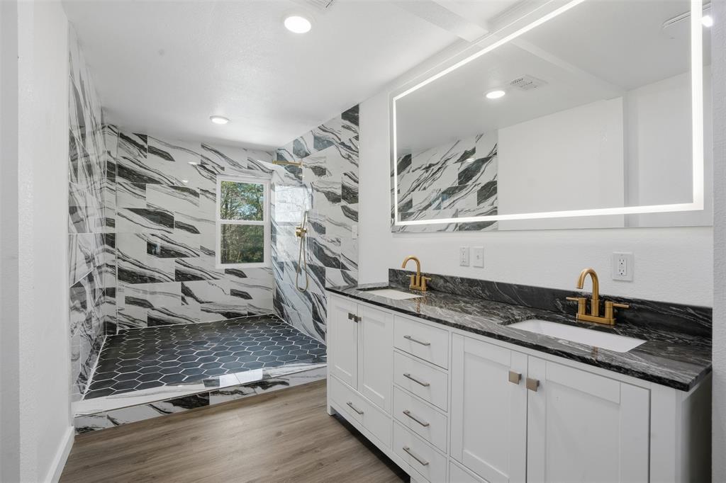 3148 Medlin Road East Mountain, TX 75645 - Photo 25 of 36 a bathroom with a granite countertop sink a mirror and shower