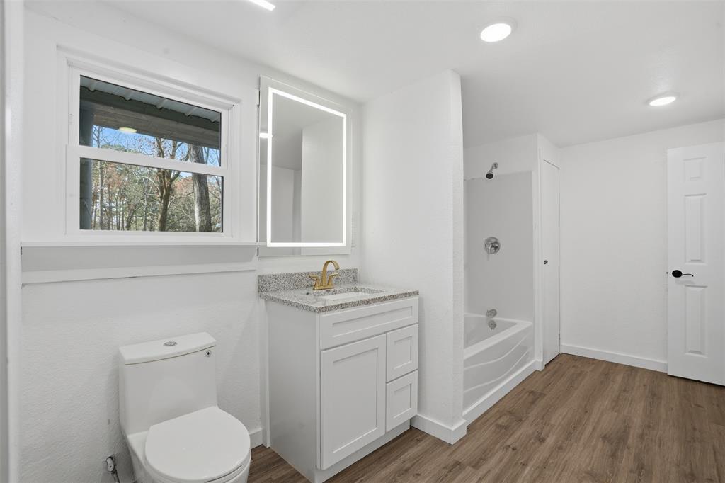 3148 Medlin Road East Mountain, TX 75645 - Photo 26 of 36 a bathroom with a toilet a sink and mirror