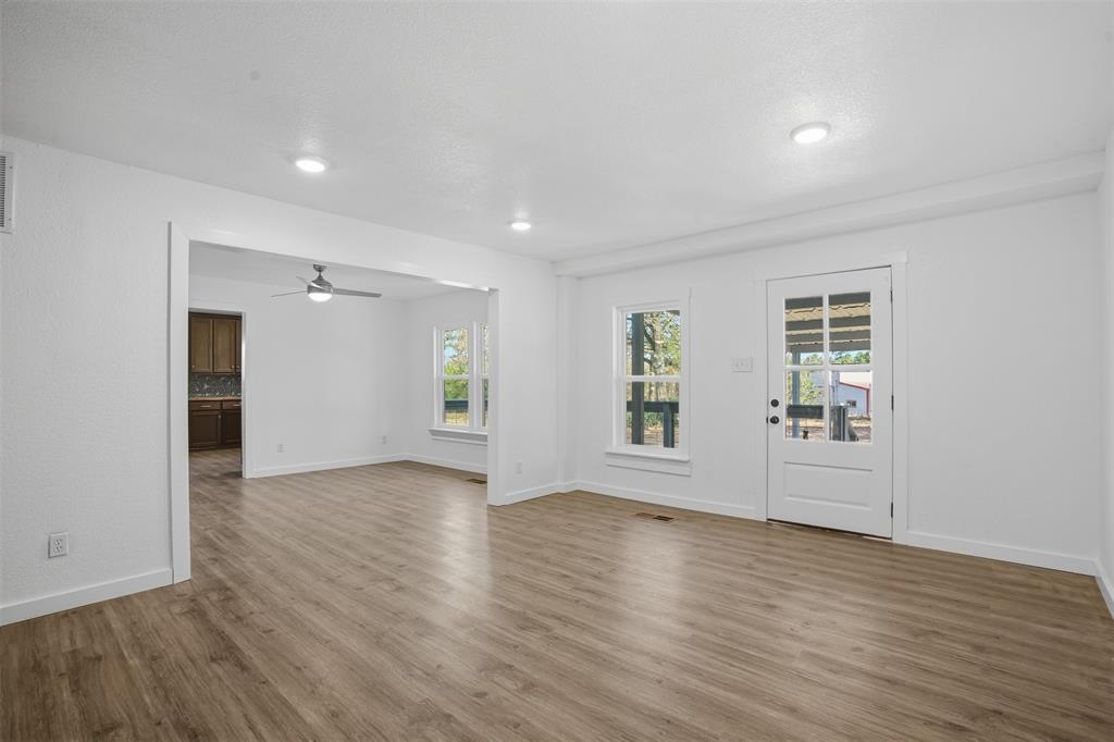 3148 Medlin Road East Mountain, TX 75645 - Photo 9 of 36 an empty room with wooden floor and windows