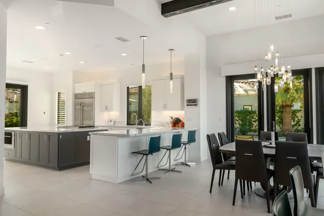 a dining room with furniture a large window and wooden floor