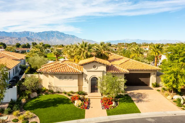 a patio with a table and chairs and potted plants