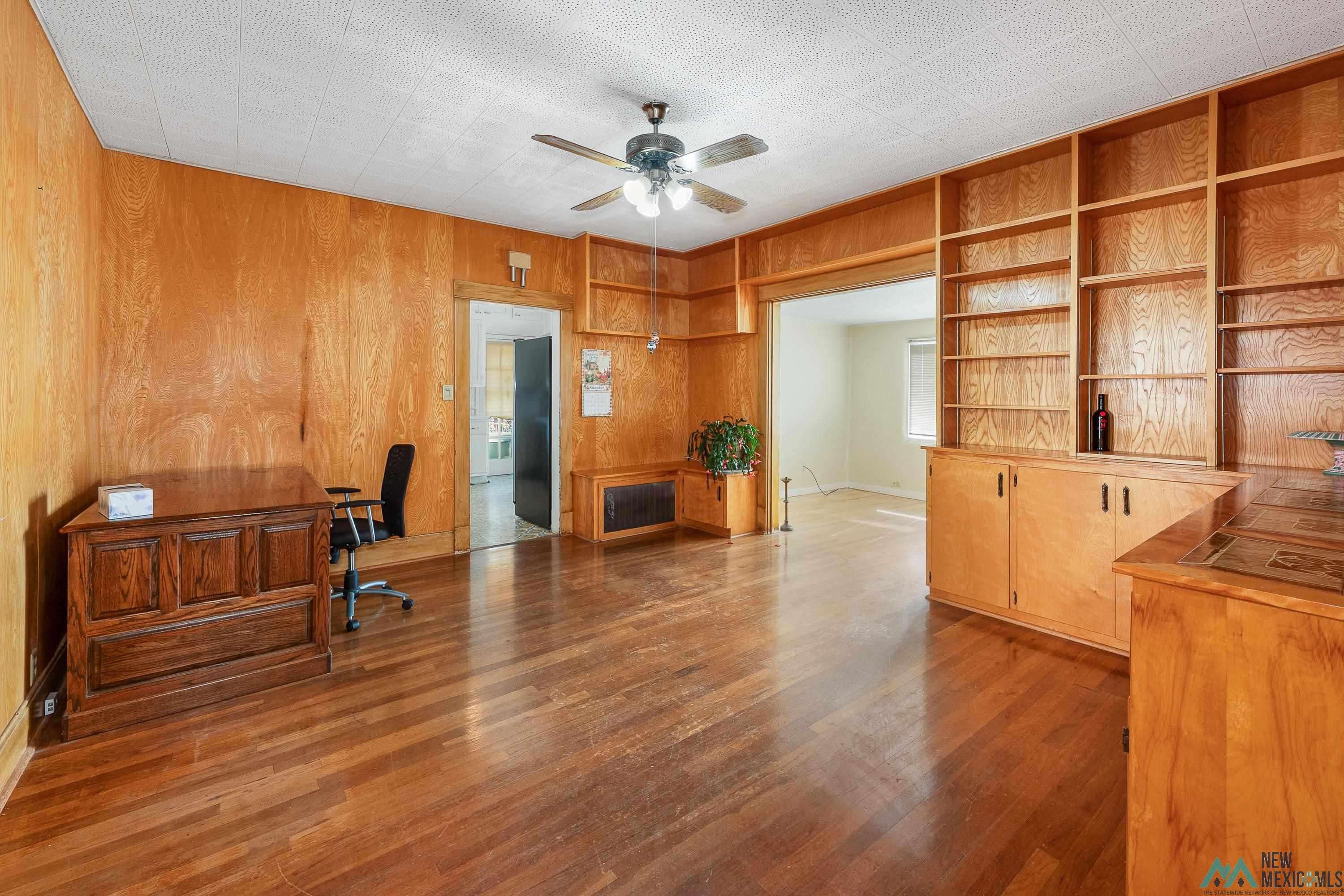 727 South 6th Street Raton, NM 87740 - Photo 8 of 47 Unfurnished office featuring wood walls, dark wood finished floors, and ceiling fan