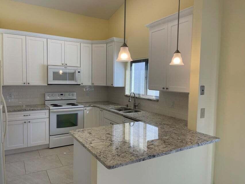 7722 Solimar Circle Boca Raton, FL 33433 - Photo 12 of 36 a kitchen with a sink a stove a microwave and island
