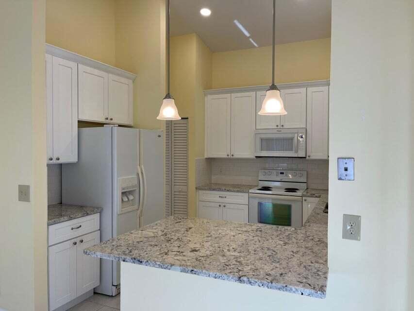 7722 Solimar Circle Boca Raton, FL 33433 - Photo 7 of 36 a kitchen with kitchen island a counter a sink stainless steel appliances and cabinets