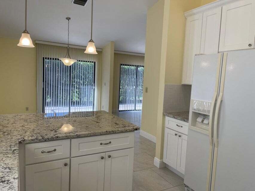 7722 Solimar Circle Boca Raton, FL 33433 - Photo 10 of 36 a kitchen with cabinets and chandelier