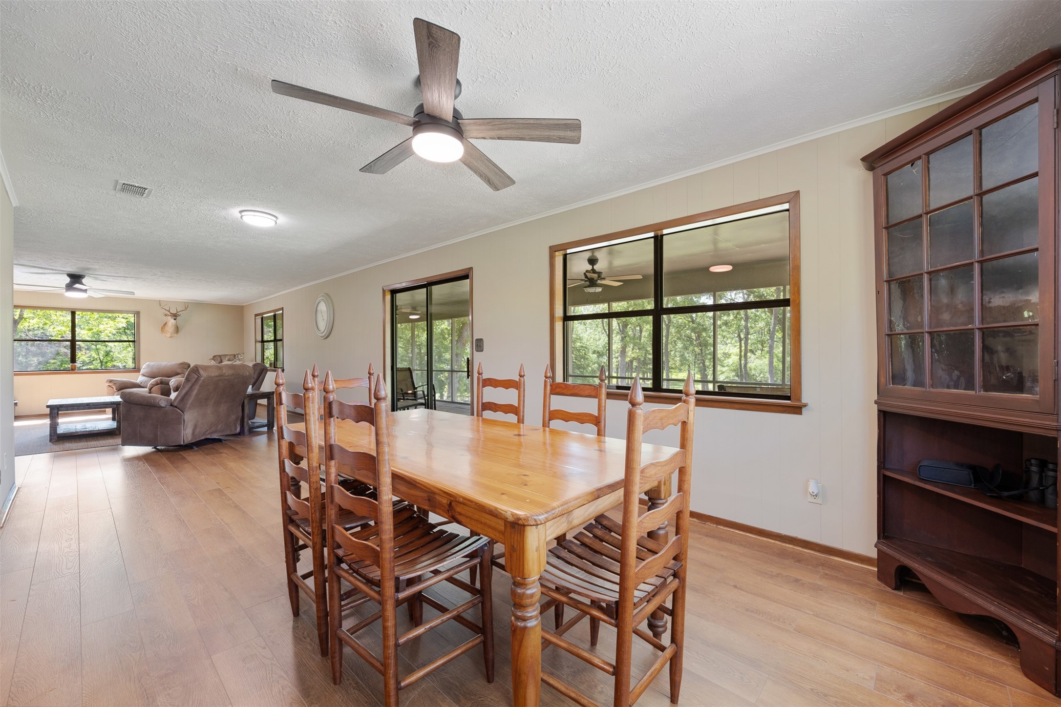 729 Centerhill Cemetery Road Crockett, TX 75835 - Photo 17 of 43 a view of a dining room and livingroom with furniture a floor to ceiling window and a ceiling fan