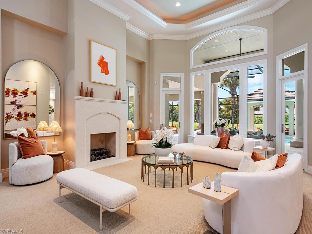 2835 Silverleaf Lane Naples, FL 34105 - Photo 4 of 47 a living room with furniture a fireplace and a large window