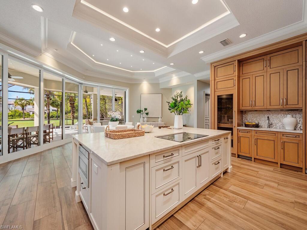 2835 Silverleaf Lane Naples, FL 34105 - Photo 7 of 47 a large kitchen with kitchen island wooden floors wooden cabinets and stainless steel appliances