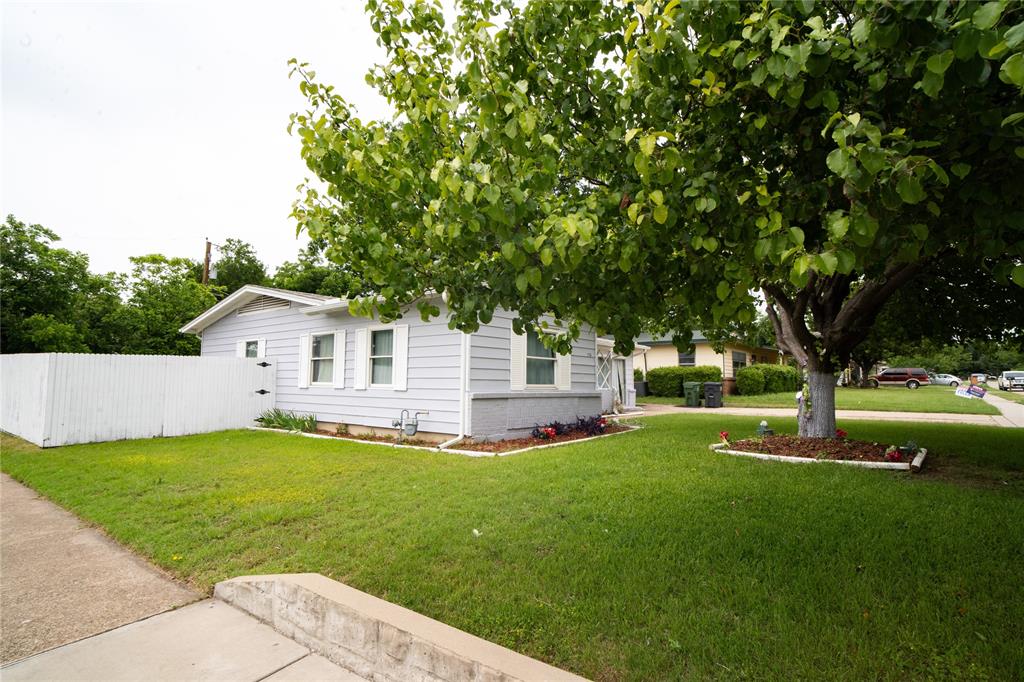 2136 Ridgeway Street Arlington, TX 76010 - Photo 4 of 32 a view of a house with a big yard potted plants and large tree