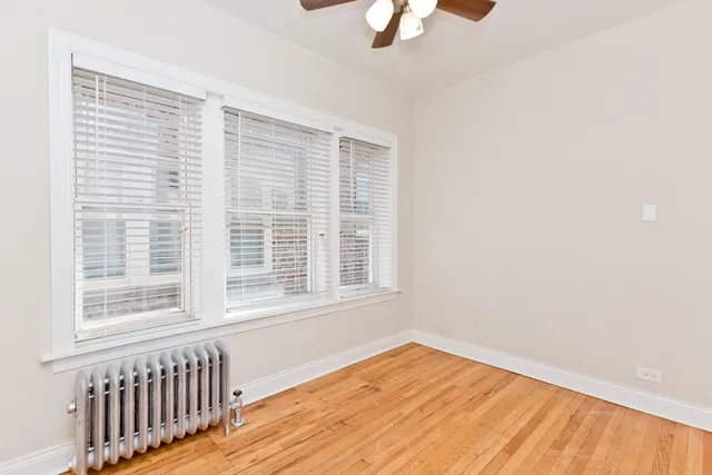 a view of a room with wooden floor and a ceiling fan