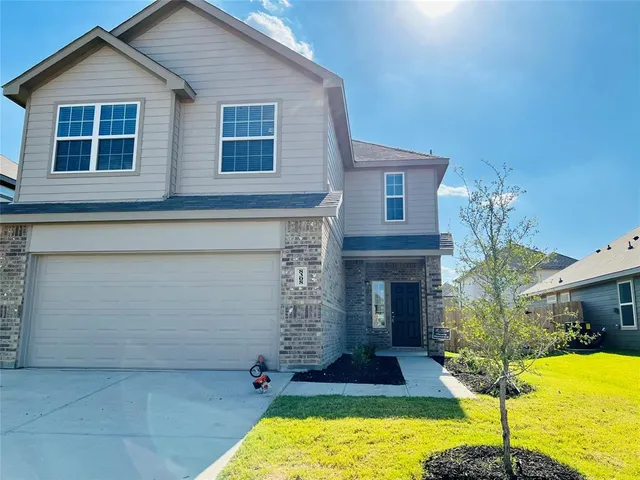 a front view of a house with yard and garage