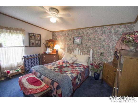 442 Van Arrington Road Clyde, NC 28721 - Photo 12 of 22 a bedroom with a bed and a chandelier