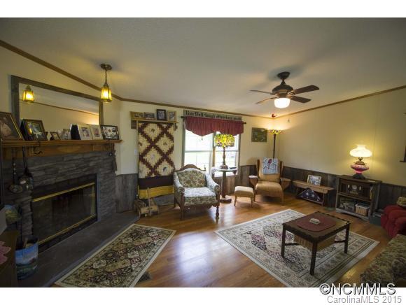 442 Van Arrington Road Clyde, NC 28721 - Photo 4 of 22 a living room with furniture a fireplace and a flat screen tv