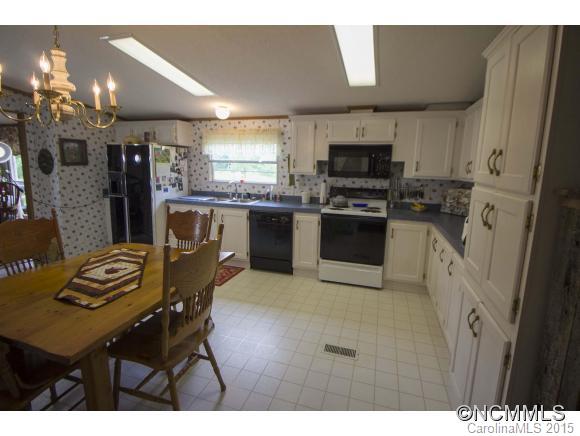 442 Van Arrington Road Clyde, NC 28721 - Photo 6 of 22 a kitchen with stainless steel appliances kitchen island granite countertop a table chairs and a refrigerator