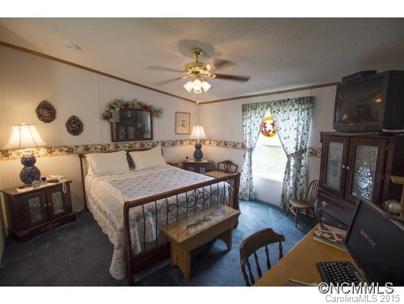 442 Van Arrington Road Clyde, NC 28721 - Photo 9 of 22 a bedroom with furniture and a chandelier