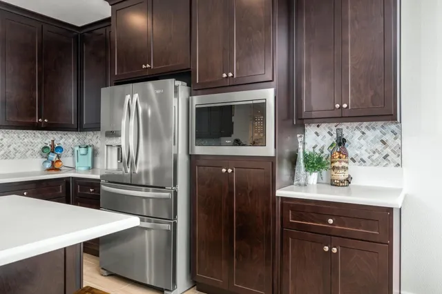 a kitchen with granite countertop wooden cabinets and refrigerator