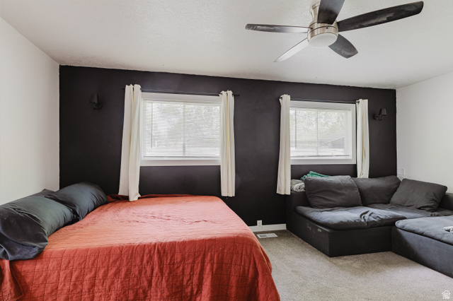 244 North 600 West Logan, UT 84321 - Photo 19 of 30 Interior room featuring a bold accent wall, two windows with blinds and curtains, and a ceiling fan