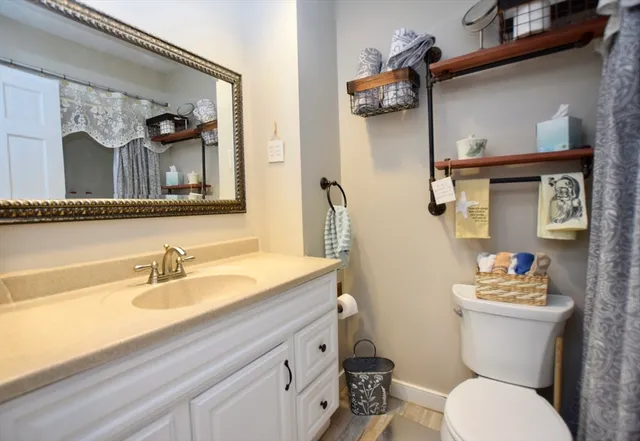 a bathroom with a toilet sink and mirror