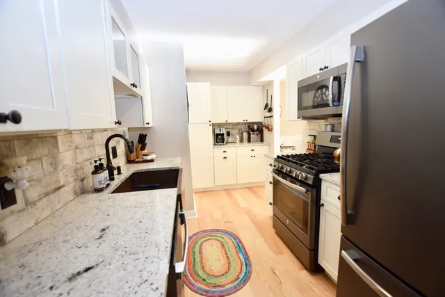 a kitchen with stainless steel appliances granite countertop a sink stove and cabinets