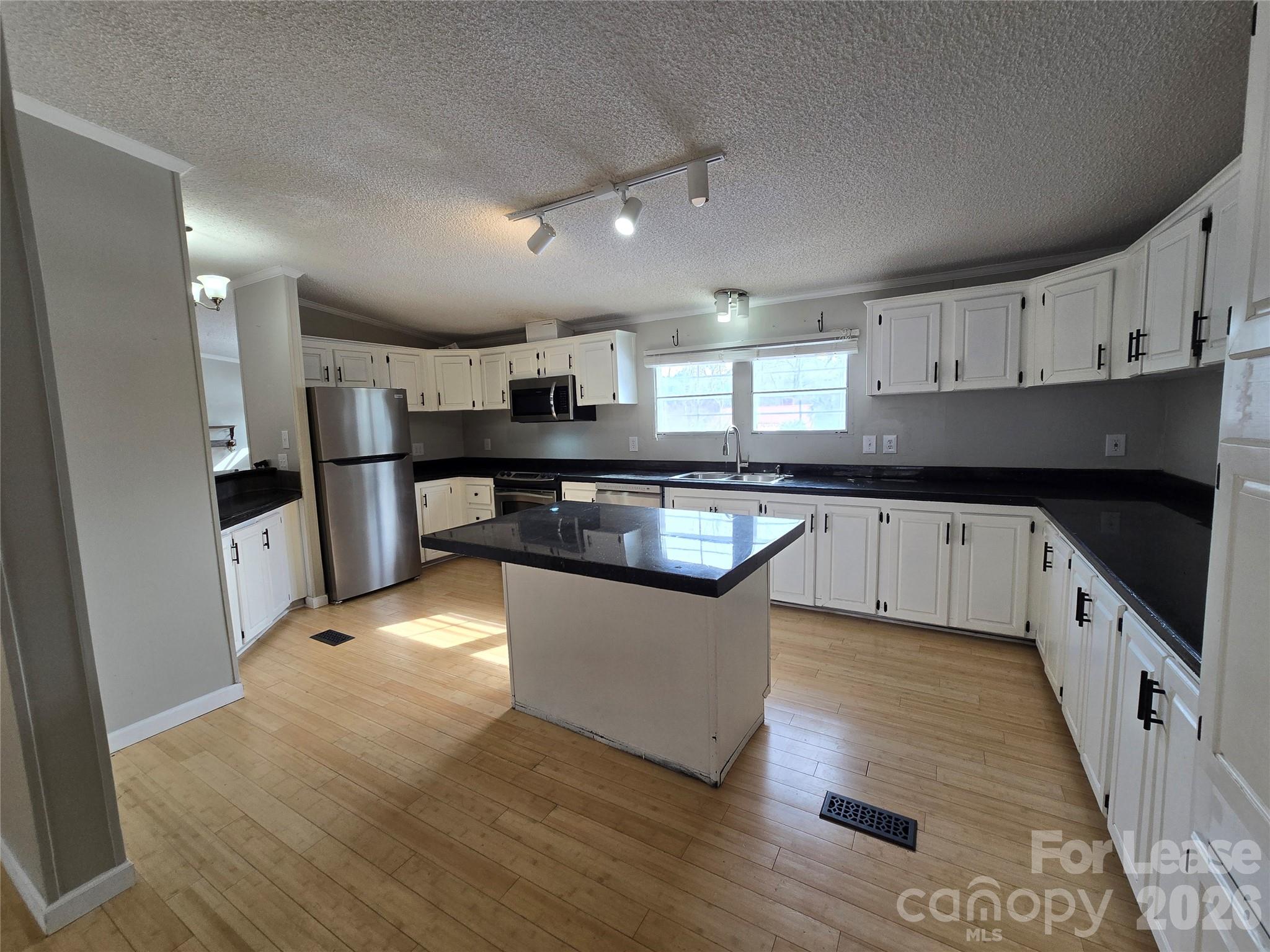 7133 Executive Circle Denver, NC 28037 - Photo 3 of 6 a large kitchen with stainless steel appliances granite countertop a stove a sink dishwasher and a refrigerator