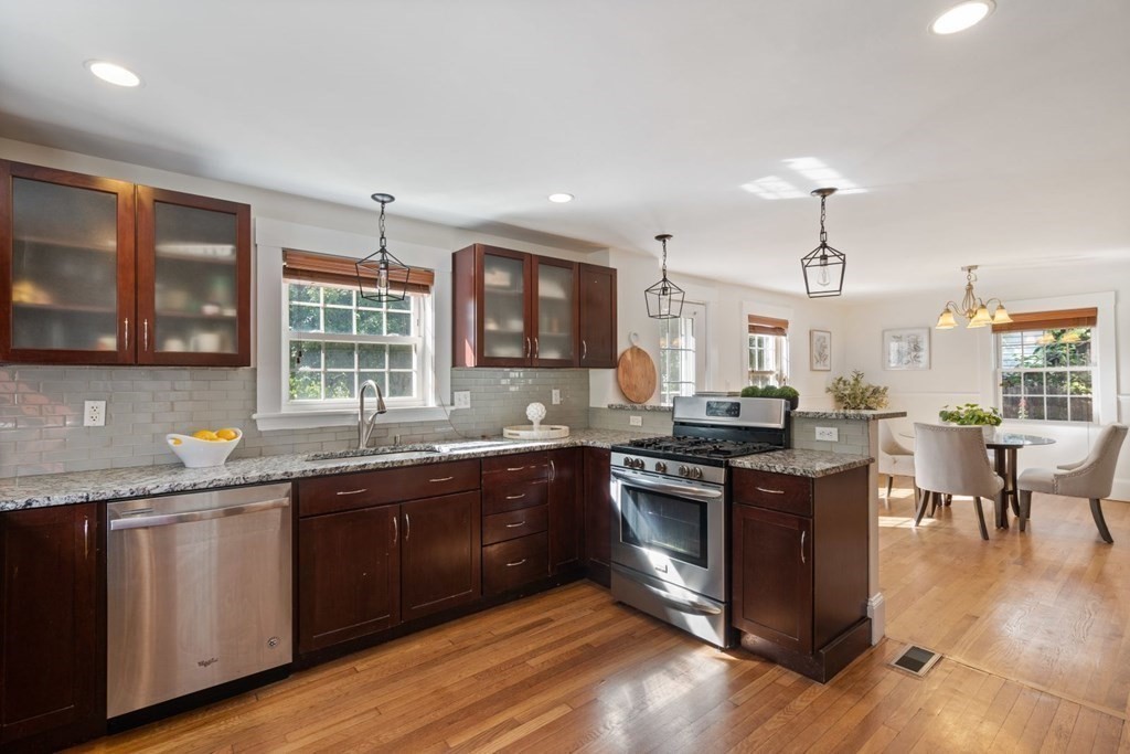 43 Hackensack Road Brookline, MA 02467 - Photo 7 of 24 a kitchen with stainless steel appliances granite countertop wooden cabinets a sink dishwasher a stove and a dining table with wooden floor