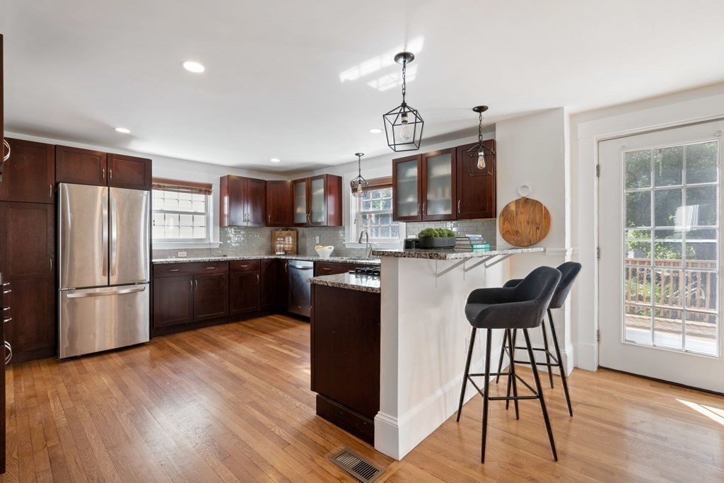43 Hackensack Road Brookline, MA 02467 - Photo 8 of 24 a kitchen with stainless steel appliances granite countertop a refrigerator a stove a sink dishwasher a dining table and chairs with wooden floor